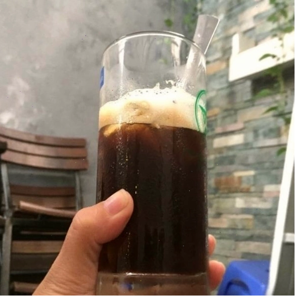 Chàng trai ngắm nhìn ly cafe với vẻ mặt trầm tư