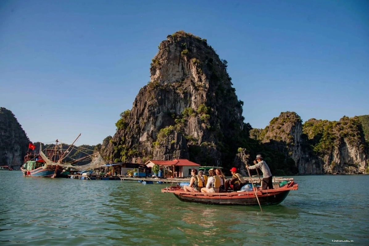 Con thuyền di chuyển trên mặt nước xanh ngắt dẫn tới làng chài nổi