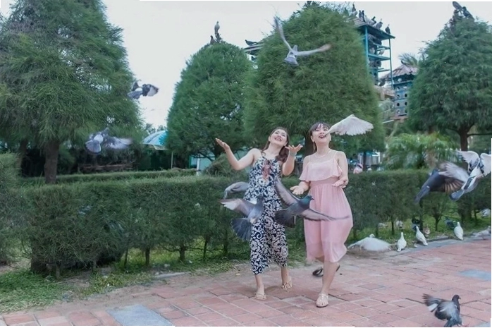 Du khách thư giãn trên bãi cỏ xanh mướt tại Công viên Biển Đông