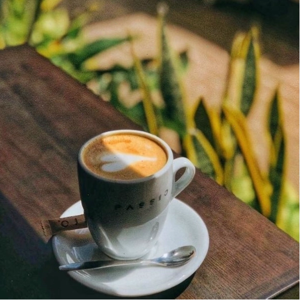 Hình ảnh bàn tay đặt trên ly cà phê, thể hiện sự suy tư