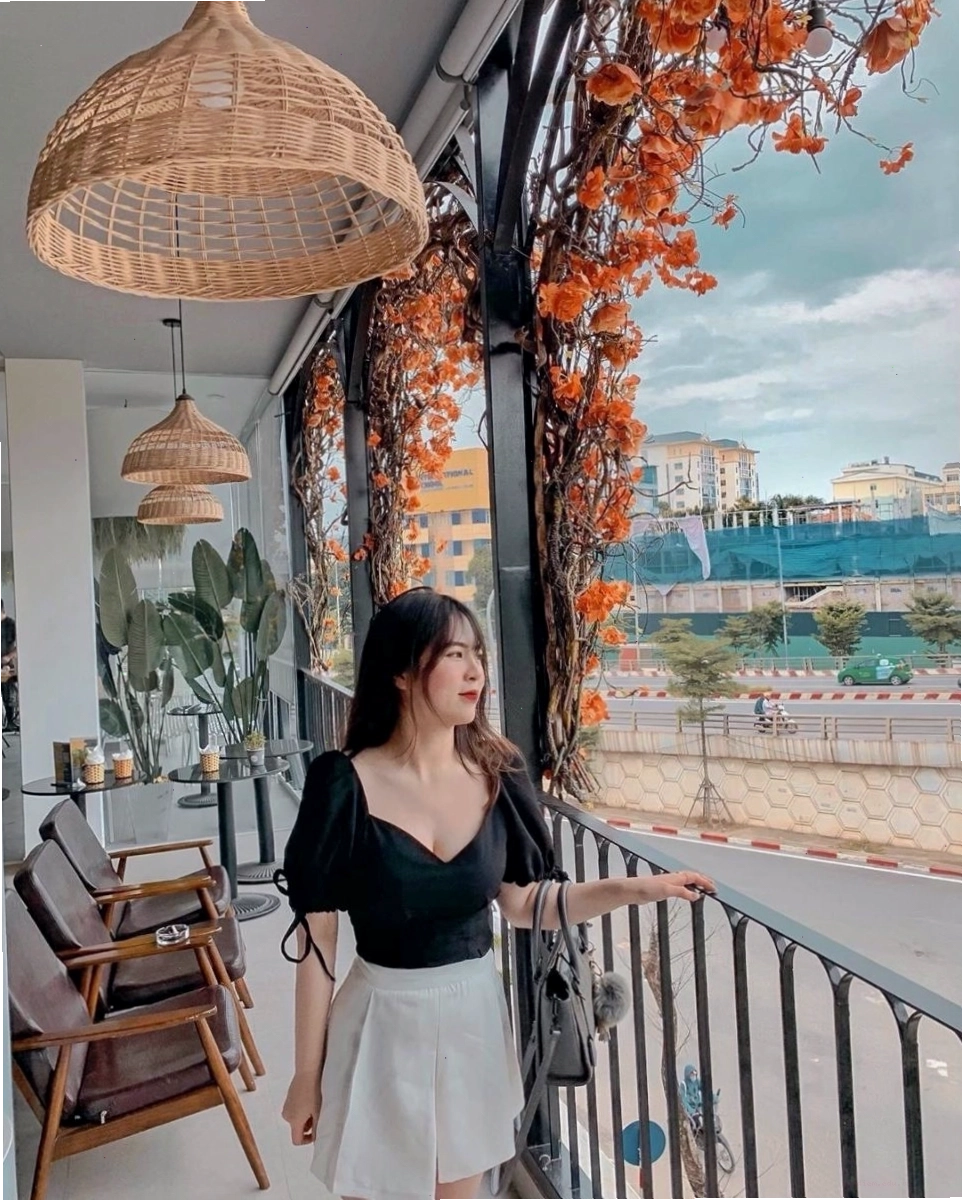 Không gian quán cafe Lê Văn Lương có cây xanh và bàn ghế ngoài trời