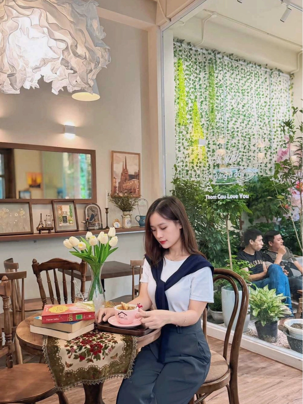 Không gian quán cafe yên tĩnh với vài khách hàng đang ngồi thưởng thức đồ uống
