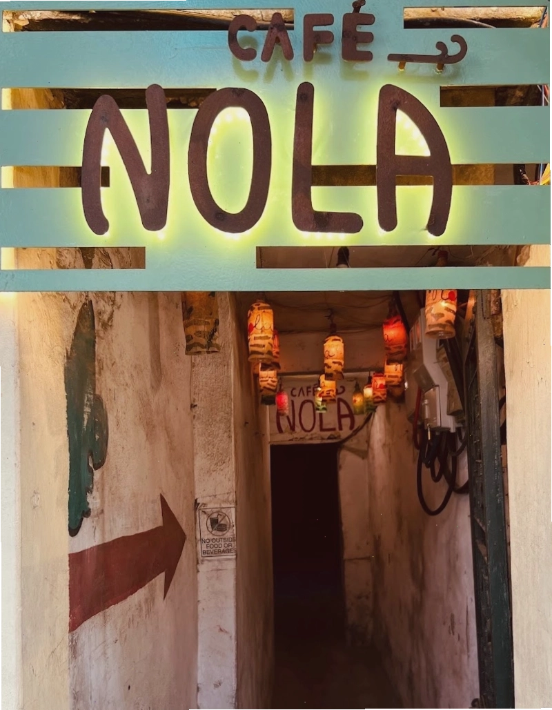Không gian tầng 1 Nola Cafe & Bar với nội thất gỗ và đèn vàng ấm áp