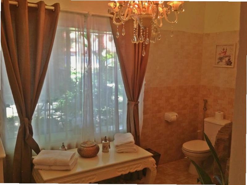 Khu vực hồ bơi ngoài trời tại Green Organic Villas với ghế tắm nắng thoải mái