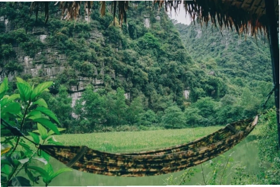 Khung cảnh yên bình của Ninh Binh Valley Homestay cạnh mặt hồ và những ngọn đồi xanh mướt