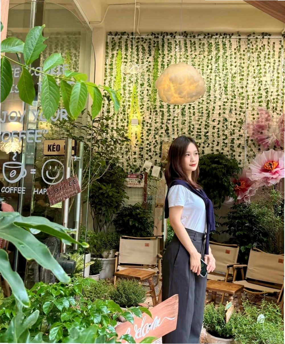 Một cô gái đang ngồi đọc sách bên cửa sổ trong quán cafe