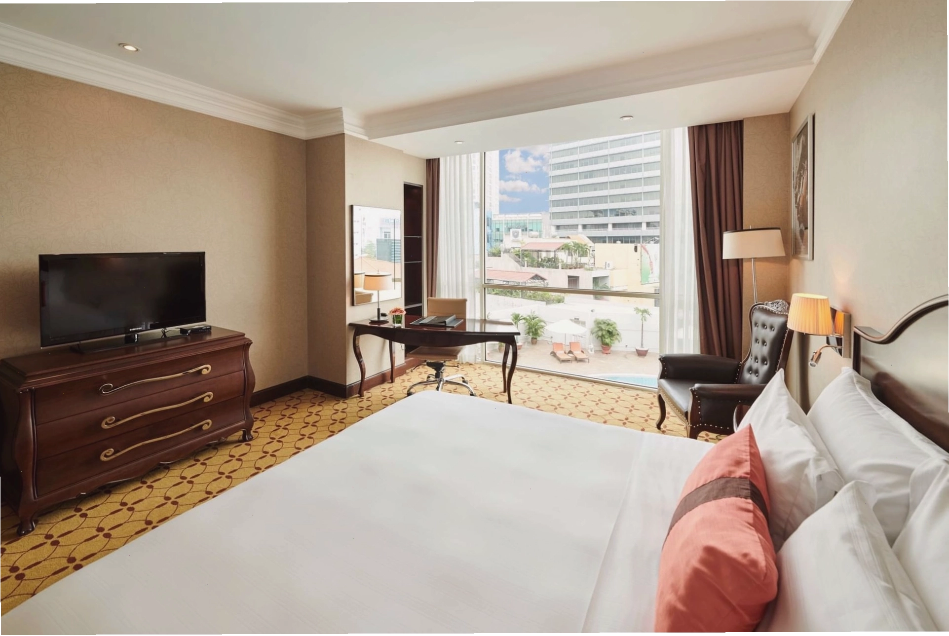Phòng Deluxe với giường cỡ lớn và khu vực ghế ngồi thoải mái tại Eastin Grand Hotel Saigon