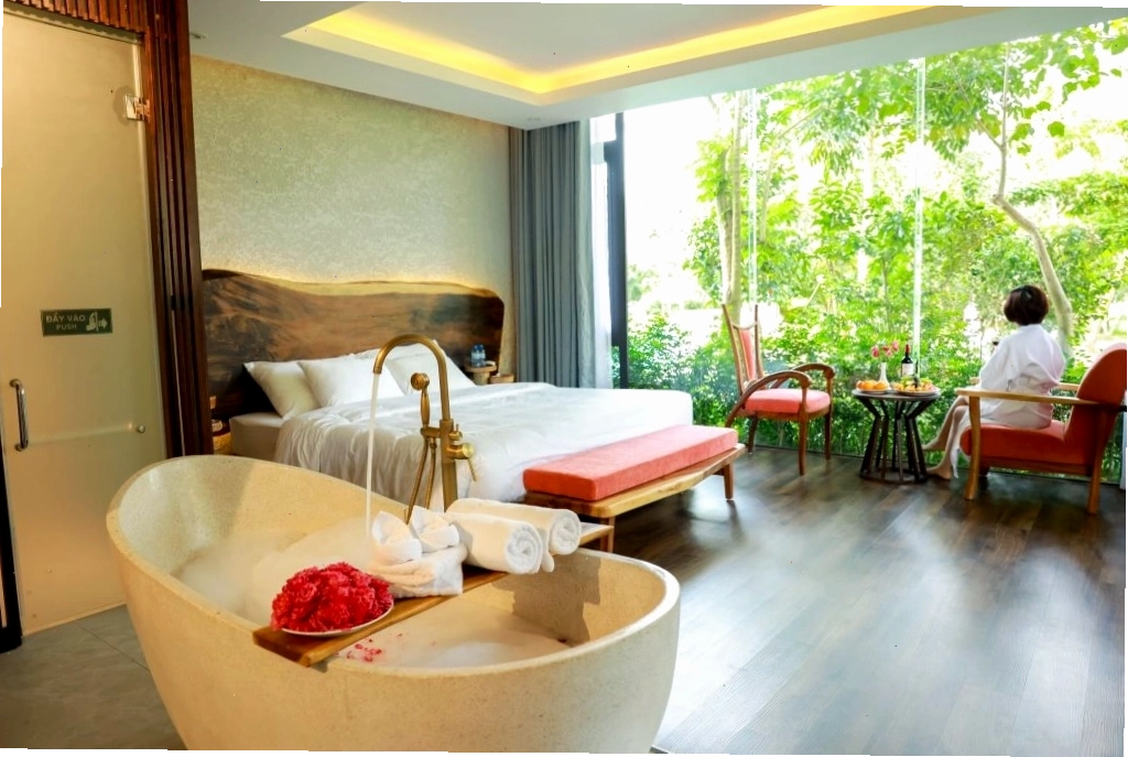 Phòng nghỉ tại Minawa Kênh Gà Resort & Spa với cửa kính sát sàn nhìn ra khung cảnh thiên nhiên