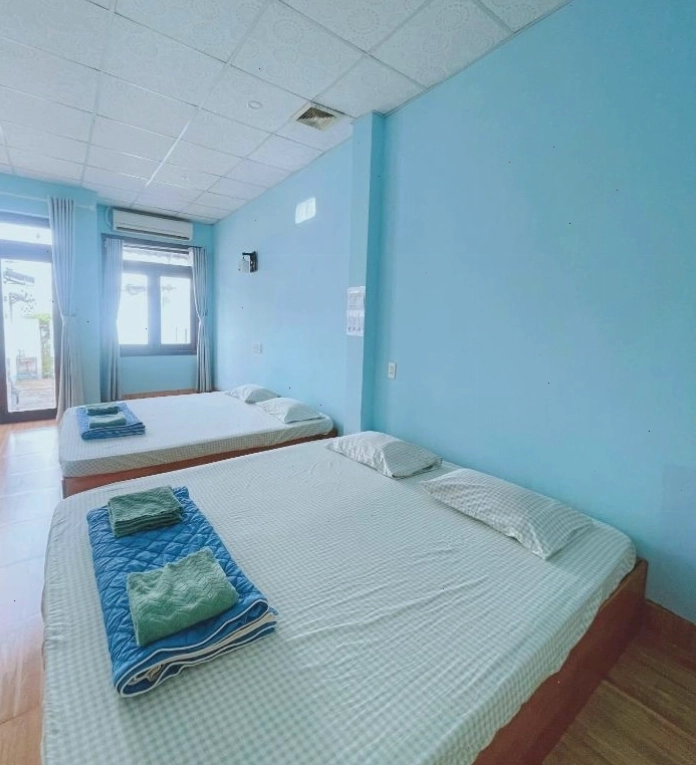 Phòng ngủ ấm cúng tại Bot Bien Homestay với 2 giường lớn