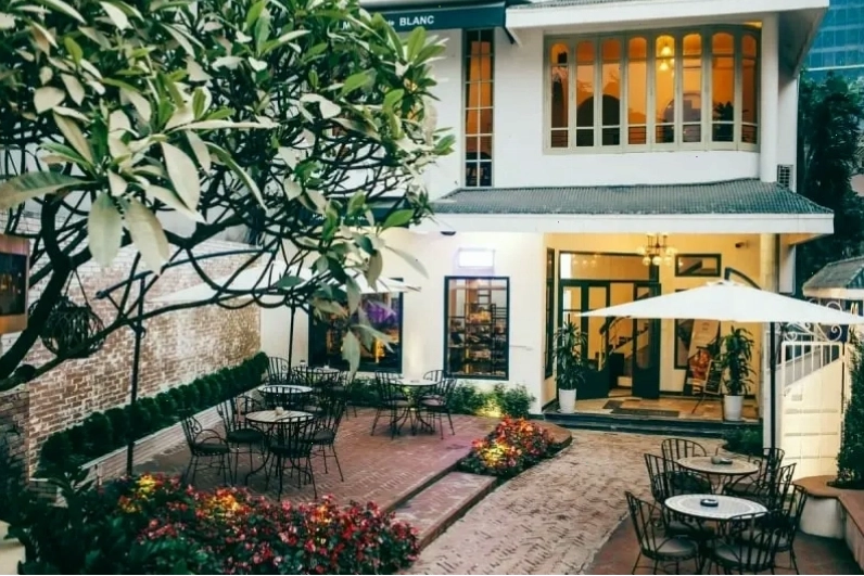 Quán cafe sân vườn với bàn ghế gỗ mộc mạc